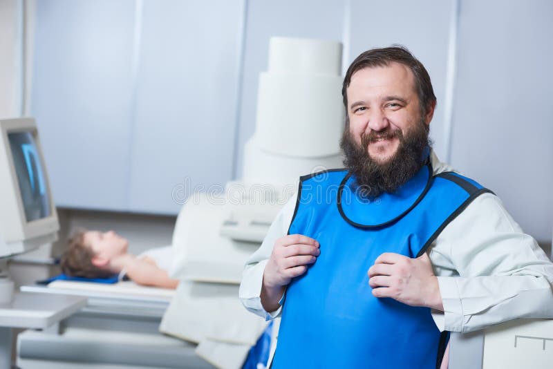 Radiology specialist portrait. Smiling male radiologist in protective wear with little boy preparing or x-ray radiography. Radiology specialist portrait. Smiling male radiologist in protective wear with little boy preparing or x-ray radiography