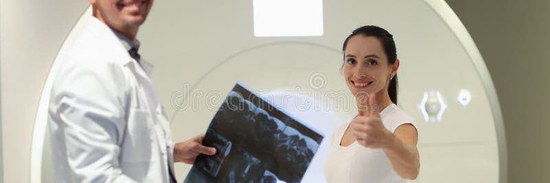 Radiologiste tient les résultats des analyses de l’irm tout en se tenant près du scanner ct et du patient. photo libre de droits