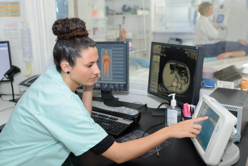 Radiologic technician monitoring mri scan female. Radiologic technician monitoring mri scan female