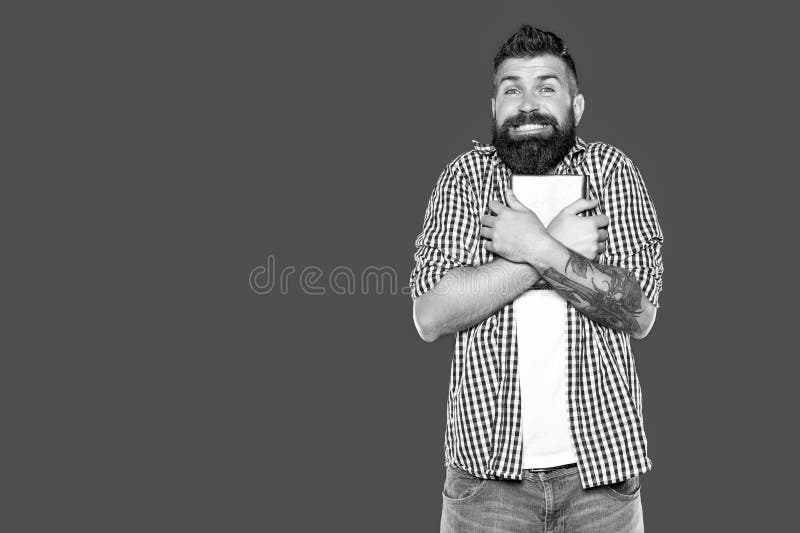 Radosny chciwy mężczyzna brodaty trzyma książkę na szarym tle fotografia stock