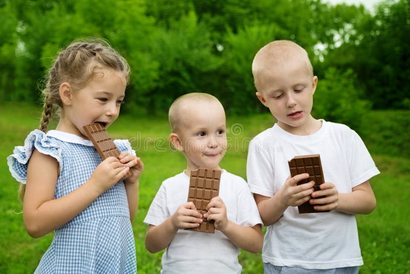 Radośni bracia, siostra i czekolada zdjęcia stock