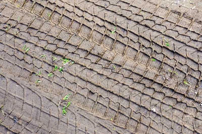 Car tire tread pattern prints in the mud, wheel protector marks texture, tyre tracks in the mud, tire prints on a wet muddy road. Car tire tread pattern prints in the mud, wheel protector marks texture, tyre tracks in the mud, tire prints on a wet muddy road