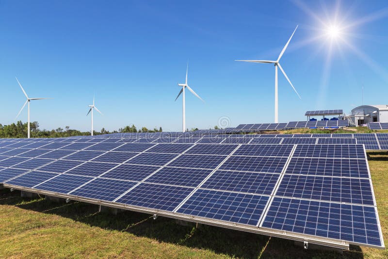 Radsamling av polycrystalline silikonsolpaneler och vindturbiner som frambringar elektricitet i hybrid- kraftverksystemstation arkivfoton