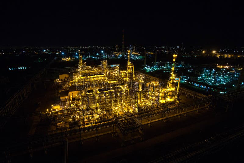 Raffineria di petrolio a penombra con i tubi e le costruzioni fotografia stock libera da diritti Raffineria di petrolio a penombra con i tubi e le costruzioni fotografia stock libera da diritti