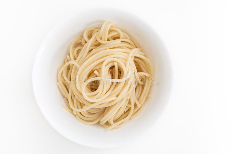 Raffinez les pâtes cuites de spaghetti dans la cuvette blanche, sur le fond blanc