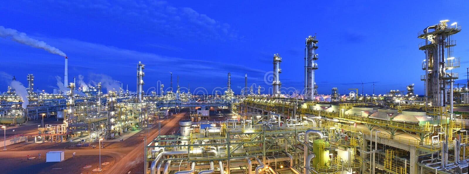 Rafinerie - Fabryka chemiczna w nocy z budynkami, rurociągami i oświetleniem - Zakłady przemysłowe Rafinerie - Fabryka chemiczna w nocy z budynkami, rurociągami i oświetleniem - Zakłady przemysłowe