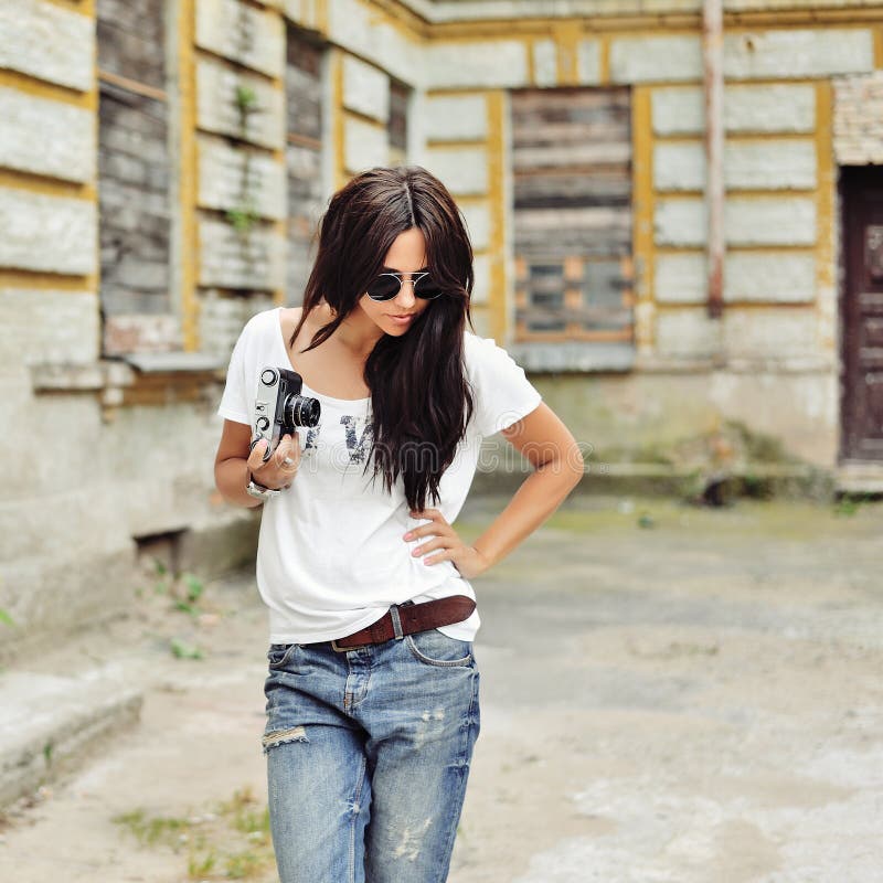 Ragazza alla moda alla moda con gli occhiali da sole d'uso della vecchia macchina fotografica e fotografie stock libere da diritti