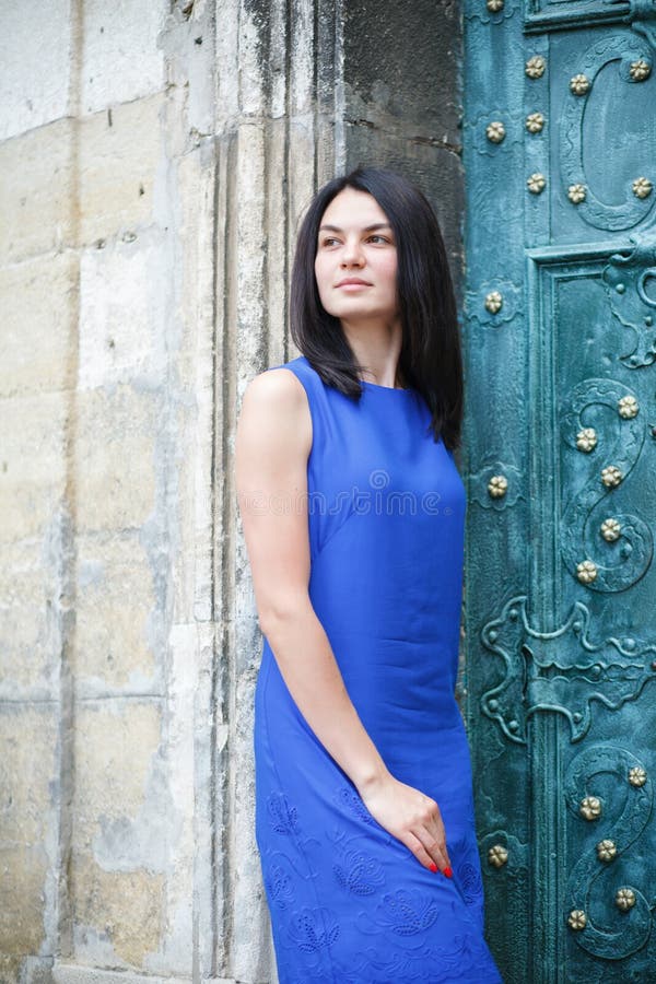 Ragazza alla moda che sta sui vecchi precedenti della porta Ritratto di una donna felice nella città fotografia stock libera da diritti Ragazza alla moda che sta sui vecchi precedenti della porta Ritratto di una donna felice nella città fotografia stock libera da diritti