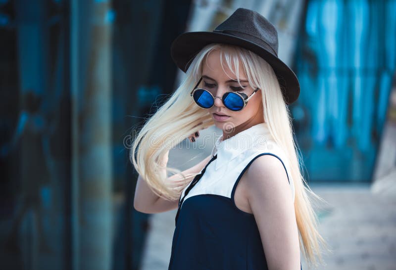 Ragazza alla moda in occhiali da sole blu fuori fotografia stock libera da diritti Ragazza alla moda in occhiali da sole blu fuori fotografia stock libera da diritti