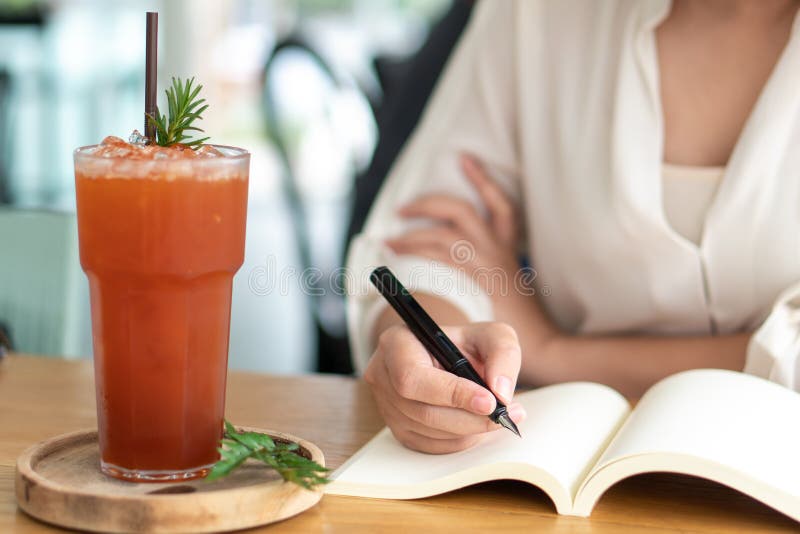 Ragazza asiatica che tiene una penna nera che scrive in un libro vuoto Le storie di scrittura del diario hanno registrato impress immagine stock libera da diritti Ragazza asiatica che tiene una penna nera che scrive in un libro vuoto Le storie di scrittura del diario hanno registrato impress immagine stock libera da diritti