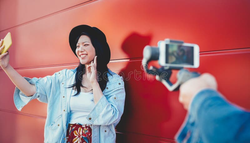 Ragazza asiatica di modo che vlogging e che per mezzo dello smartphone mobile all'aperto - donna cinese d'avanguardia felice dive fotografie stock Ragazza asiatica di modo che vlogging e che per mezzo dello smartphone mobile all'aperto - donna cinese d'avanguardia felice dive fotografie stock
