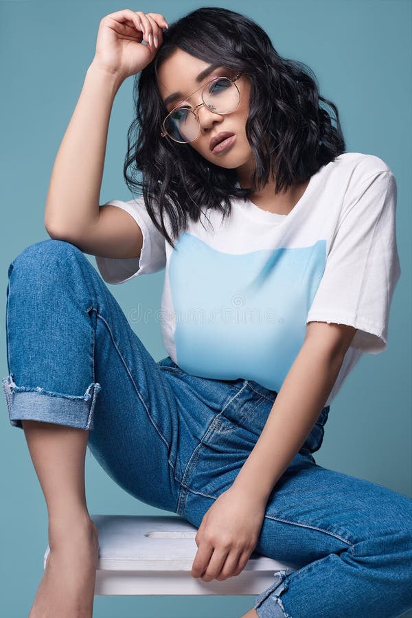 Ragazza asiatica sexy elegante in jeans e maglietta bianca su fondo luminoso fotografie stock libere da diritti Ragazza asiatica sexy elegante in jeans e maglietta bianca su fondo luminoso fotografie stock libere da diritti