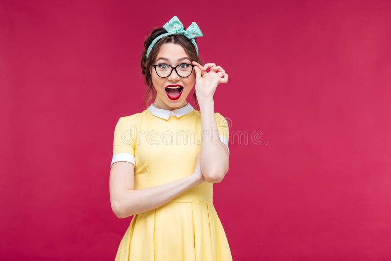 Ragazza attraente felice del pinup in dreass e vetri gialli fotografia stock libera da diritti
