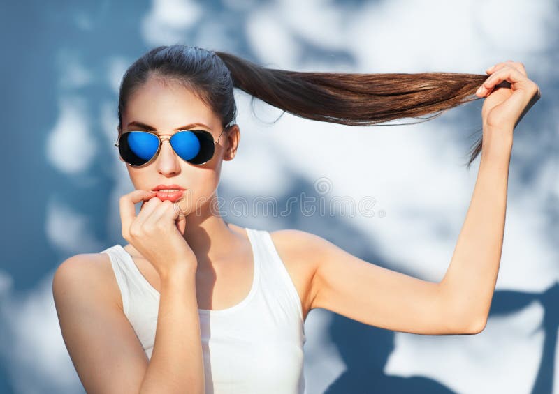 Ragazza attraente in occhiali da sole blu rispecchiati fotografia stock Ragazza attraente in occhiali da sole blu rispecchiati fotografia stock