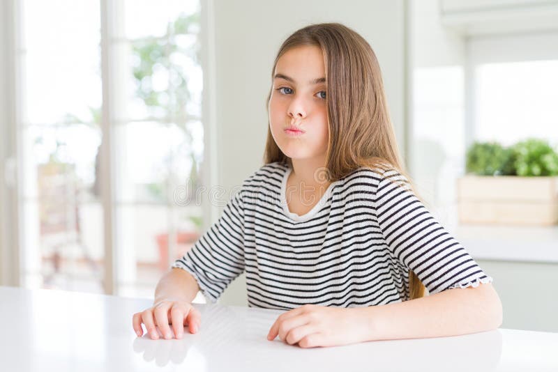 Ragazza bellissima con strisce di camicia gonfia di guance con viso buffo fotografia stock libera da diritti