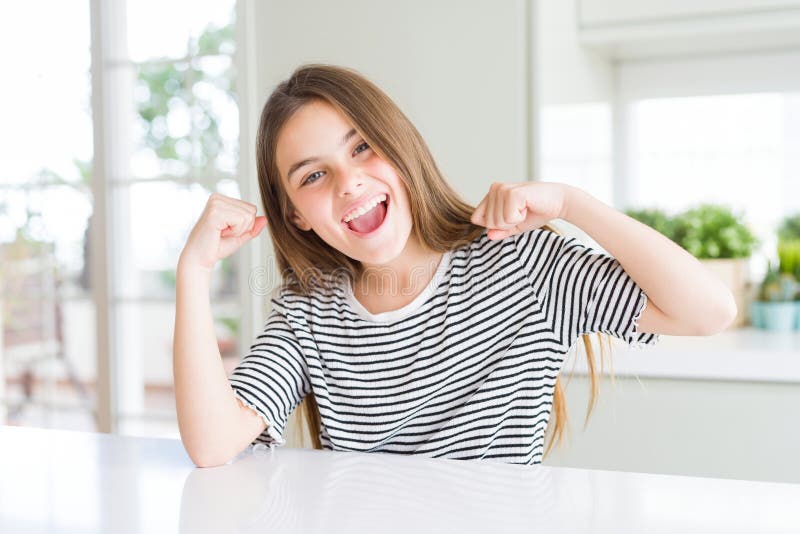 Ragazza bellissima con una camicia a strisce che mostra muscoli delle braccia sorridenti fotografia stock