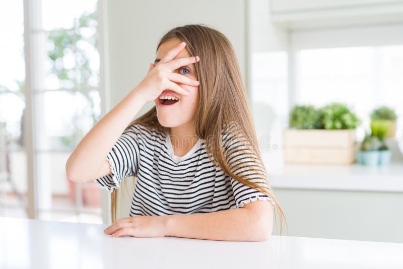 Ragazza bellissima, con una camicia a strisce, con gli occhi e la faccia sotto shock, che guarda a mano con le dita fotografia stock libera da diritti