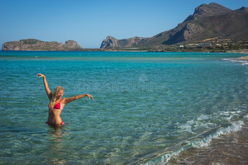 Ragazza in bikini rosso sulla spiaggia di Creta fotografia stock libera da diritti Ragazza in bikini rosso sulla spiaggia di Creta fotografia stock libera da diritti