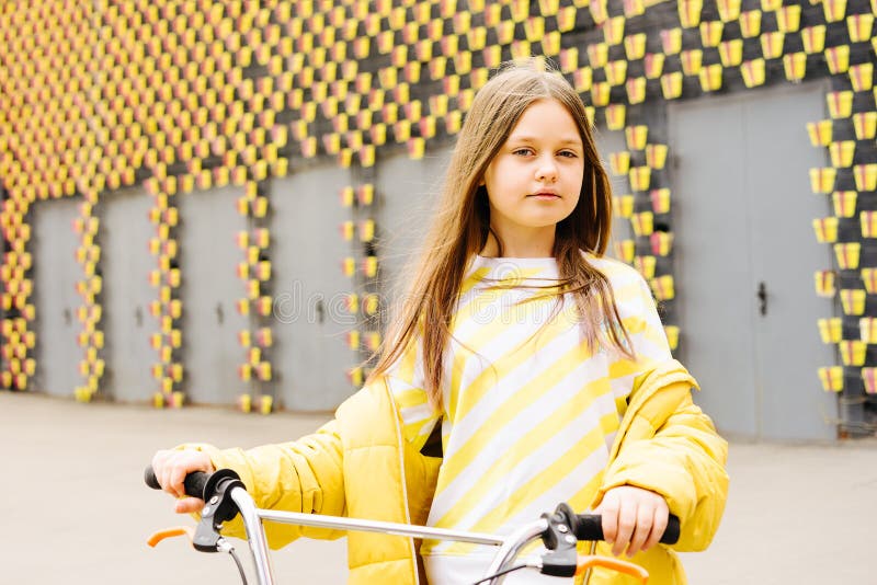 Ragazza bionda dai capelli lunghi in un maglione giallo ed in un rivestimento giallo immagini stock Ragazza bionda dai capelli lunghi in un maglione giallo ed in un rivestimento giallo immagini stock