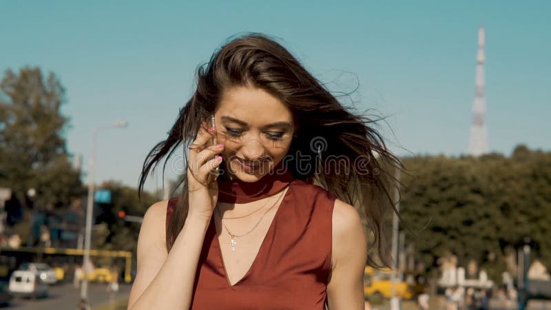 Ragazza castana felice con il telefono