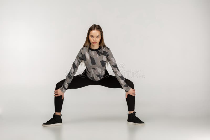 Ragazza castana muscolare in buona salute in abiti sportivi che fanno resistenza della squadra fotografia stock libera da diritti Ragazza castana muscolare in buona salute in abiti sportivi che fanno resistenza della squadra fotografia stock libera da diritti