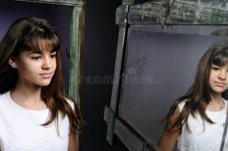 Ragazza caucasica che osserva in specchio fotografia stock libera da diritti Ragazza caucasica che osserva in specchio fotografia stock libera da diritti
