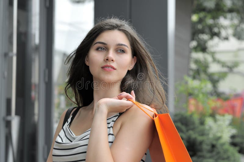 Ragazza che cammina con i sacchetti della spesa immagini stock Ragazza che cammina con i sacchetti della spesa immagini stock