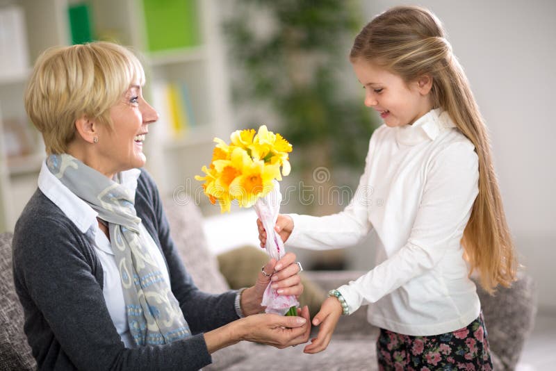 Ragazza che dà un mazzo di fiori a sua nonna
