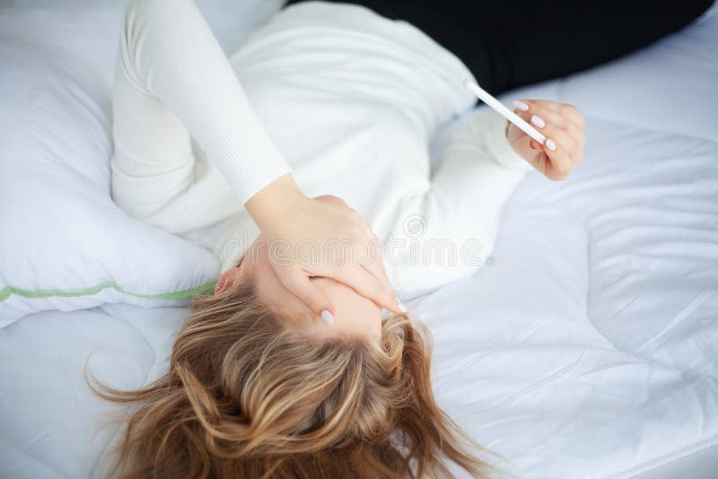 Ragazza che esamina la donna triste del test di gravidanza che aspetta i risultati dei test incinti immagine stock Ragazza che esamina la donna triste del test di gravidanza che aspetta i risultati dei test incinti immagine stock