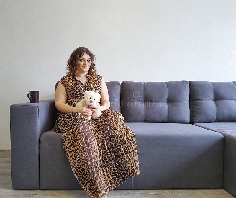 Ragazza che felice la tenuta di emozioni della tenerezza del giocattolo dell'orsacchiotto del sofà si rilassa fotografie stock Ragazza che felice la tenuta di emozioni della tenerezza del giocattolo dell'orsacchiotto del sofà si rilassa fotografie stock