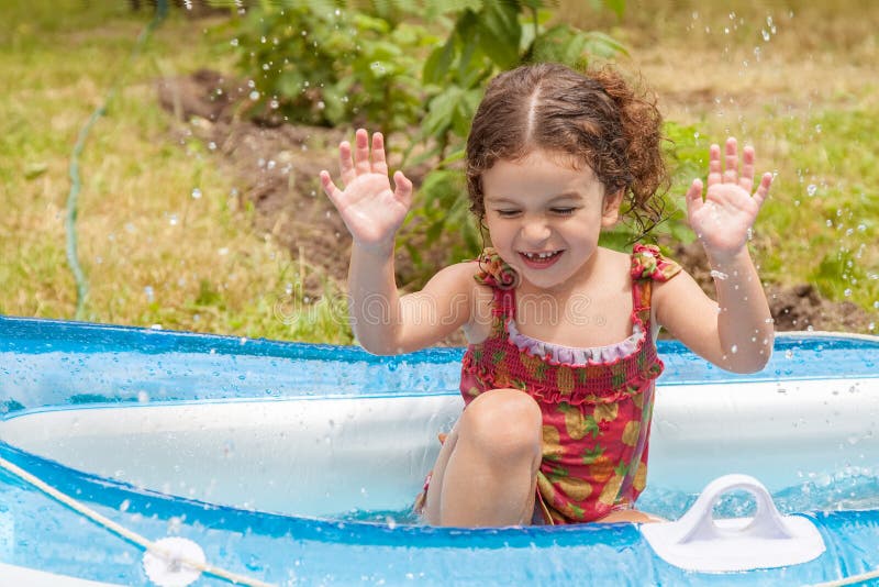 Ragazza che gioca in barca gonfiabile con acqua immagini stock libere da diritti Ragazza che gioca in barca gonfiabile con acqua immagini stock libere da diritti