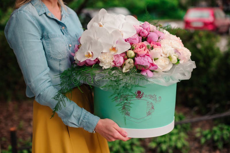 Ragazza che giudica bella miscela mazzo bianco e rosa del fiore in scatola rotonda con il coperchio immagine stock Ragazza che giudica bella miscela mazzo bianco e rosa del fiore in scatola rotonda con il coperchio immagine stock