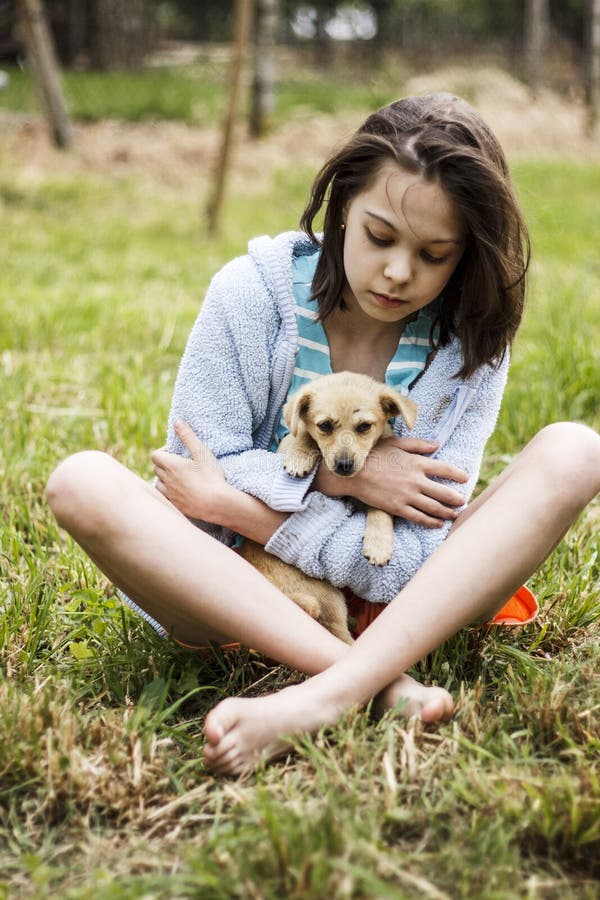 Ragazza che prende cura per un piccolo cucciolo immagine stock libera da diritti Ragazza che prende cura per un piccolo cucciolo immagine stock libera da diritti