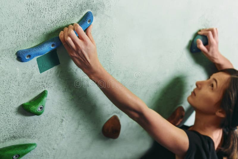 Ragazza che scala sulla parete della roccia dell'interno fotografia stock Ragazza che scala sulla parete della roccia dell'interno fotografia stock