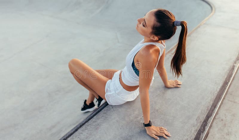 Ragazza che si rilassa dopo la sessione intensa di allenamento fotografia stock Ragazza che si rilassa dopo la sessione intensa di allenamento fotografia stock