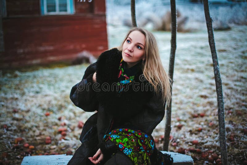 Ragazza che si siede su un banco nel vill fotografia stock Ragazza che si siede su un banco nel vill fotografia stock