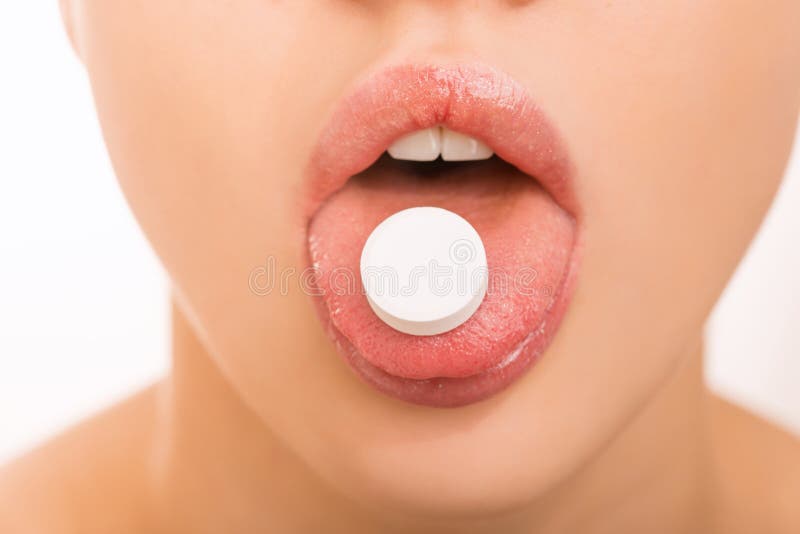 Ragazza che tiene una pillola sulla sua lingua fotografie stock Ragazza che tiene una pillola sulla sua lingua fotografie stock