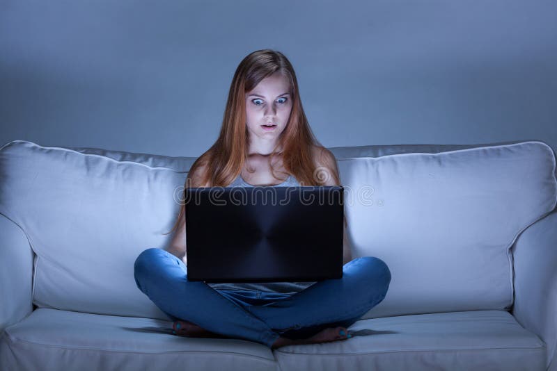 Ragazza colpita che usando facebook alla notte fotografia stock Ragazza colpita che usando facebook alla notte fotografia stock