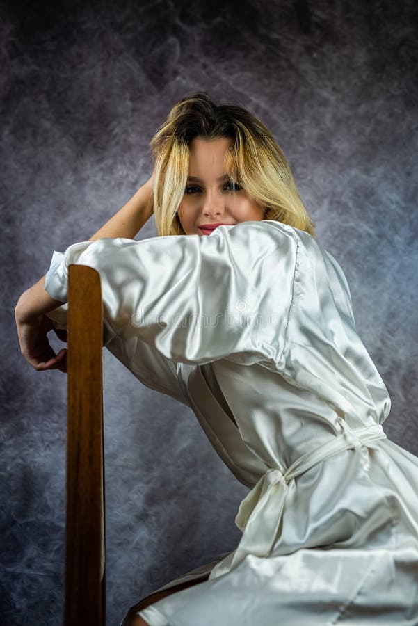 Ragazza con capelli e trucco fantastici in veste erotica bianca e biancheria intima in studio. immagine stock