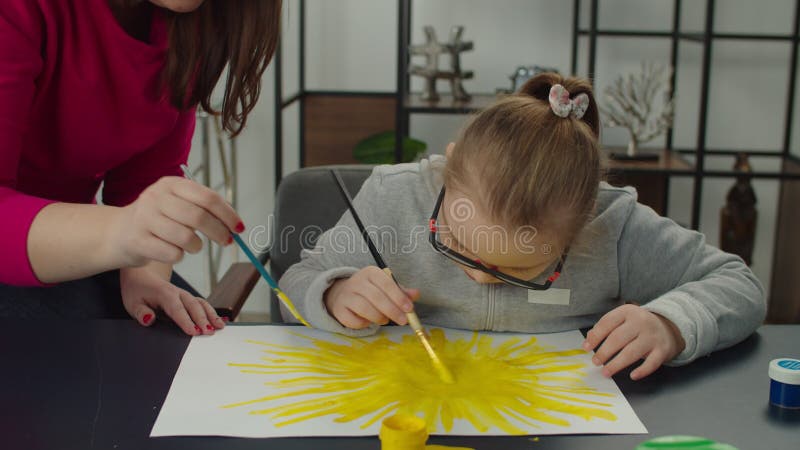 Ragazza con disabilità intellettuale che esprime creatività nella pittura stock footage