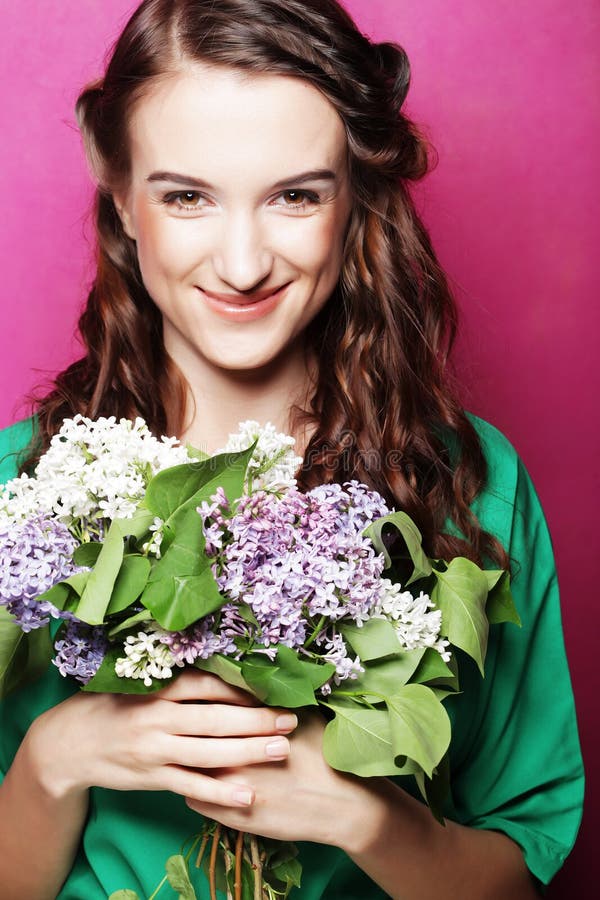 Ragazza con i fiori lilla sopra fondo rosa fotografie stock Ragazza con i fiori lilla sopra fondo rosa fotografie stock
