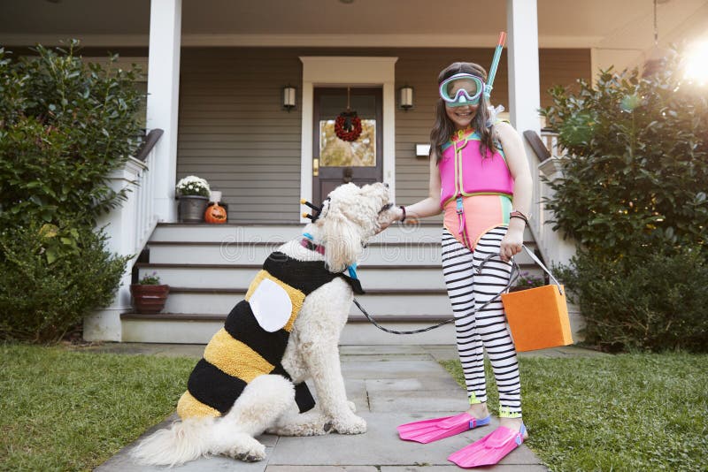 Ragazza con il cane che porta i costumi di Halloween per il trucco o trattare immagine stock Ragazza con il cane che porta i costumi di Halloween per il trucco o trattare immagine stock