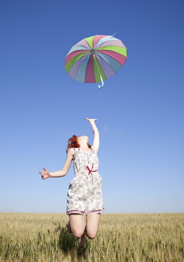 Girl with umbrella jumping at field. Photo #1. Girl with umbrella jumping at field. Photo #1