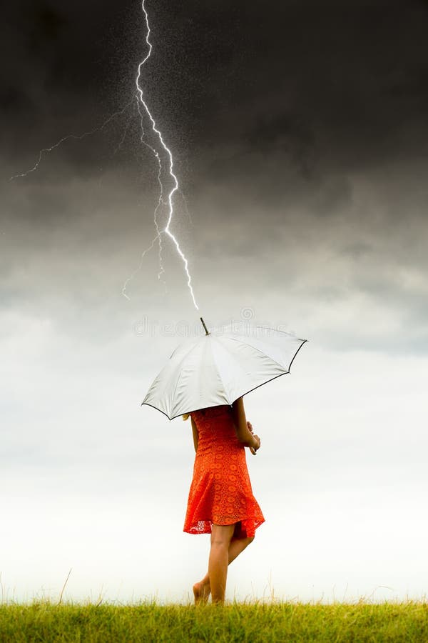 Ragazza con l'ombrello in tempesta fotografie stock Ragazza con l'ombrello in tempesta fotografie stock