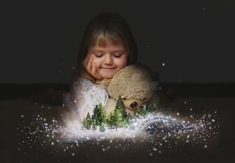 Ragazza con l'orsacchiotto, che guarda una foresta incantata sulle pagine di un libro magico aperto fotografie stock