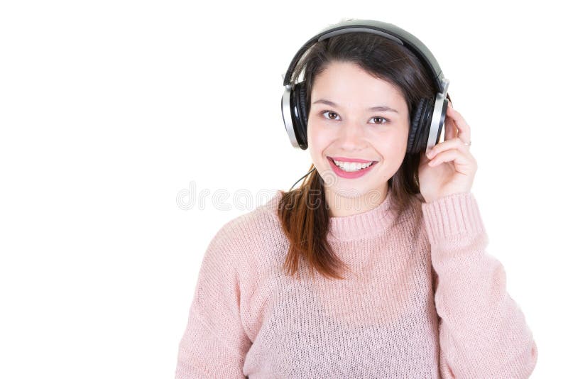Ragazza con la donna dai capelli d'ascolto di Brown di musica delle grandi cuffie con capelli lunghi in vestiti rosa del maglione immagini stock libere da diritti Ragazza con la donna dai capelli d'ascolto di Brown di musica delle grandi cuffie con capelli lunghi in vestiti rosa del maglione immagini stock libere da diritti