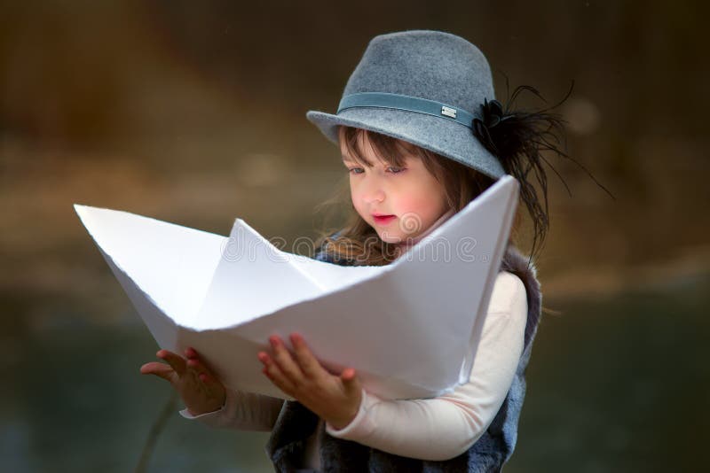 Ragazza con la grande barca di carta immagini stock Ragazza con la grande barca di carta immagini stock