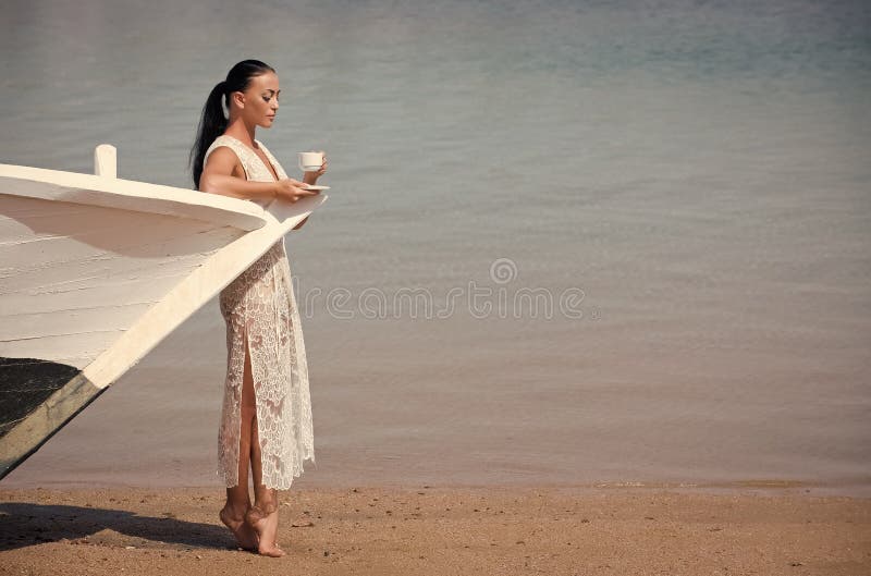 Ragazza con la tazza di caffè alla barca fotografia stock libera da diritti Ragazza con la tazza di caffè alla barca fotografia stock libera da diritti