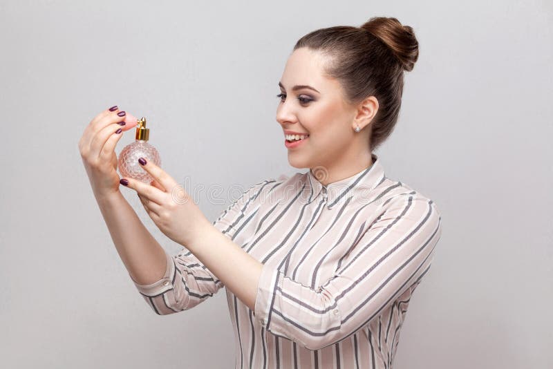 Ragazza con profumo Ragazza abbastanza sorridente della giovane donna del ritratto di vista laterale del primo piano bella in bot fotografia stock Ragazza con profumo Ragazza abbastanza sorridente della giovane donna del ritratto di vista laterale del primo piano bella in bot fotografia stock