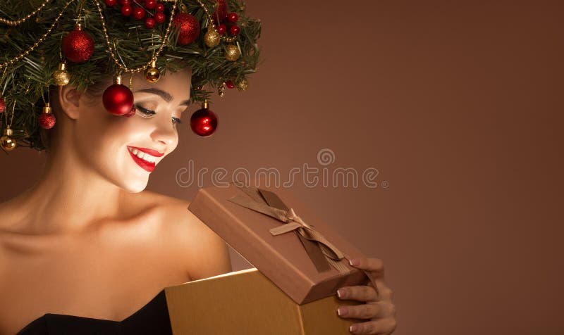 Ragazza con una corona di natale sulla testa Apri scatola regalo magica fotografie stock libere da diritti